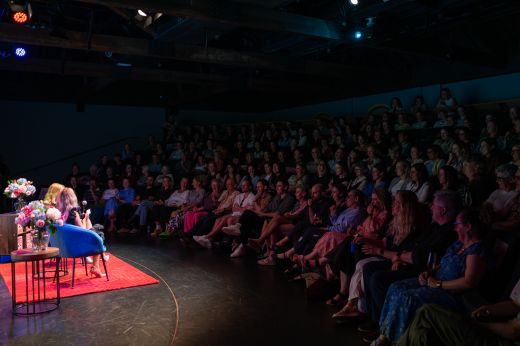 A appreciative audience listens to two guest speakers conversing on stage