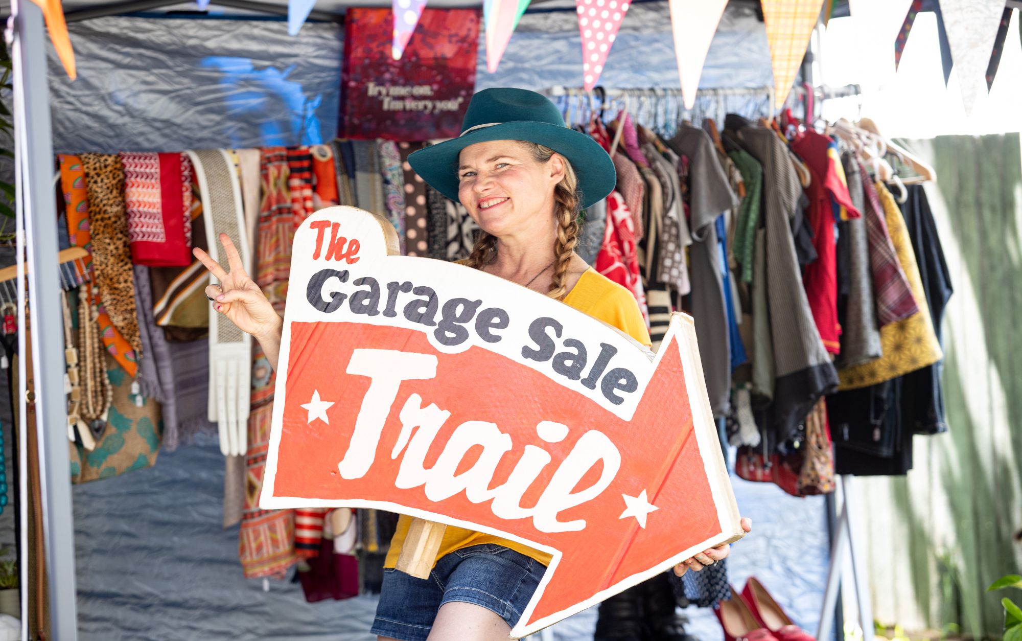 Woman holding Garage Sale Trail arrow sign