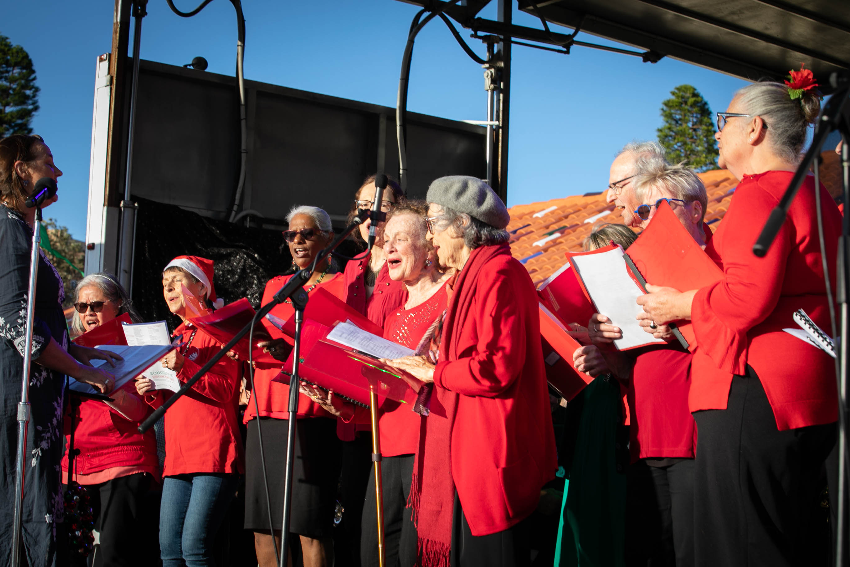 A very happy group of seniors on stage standing together singing carols