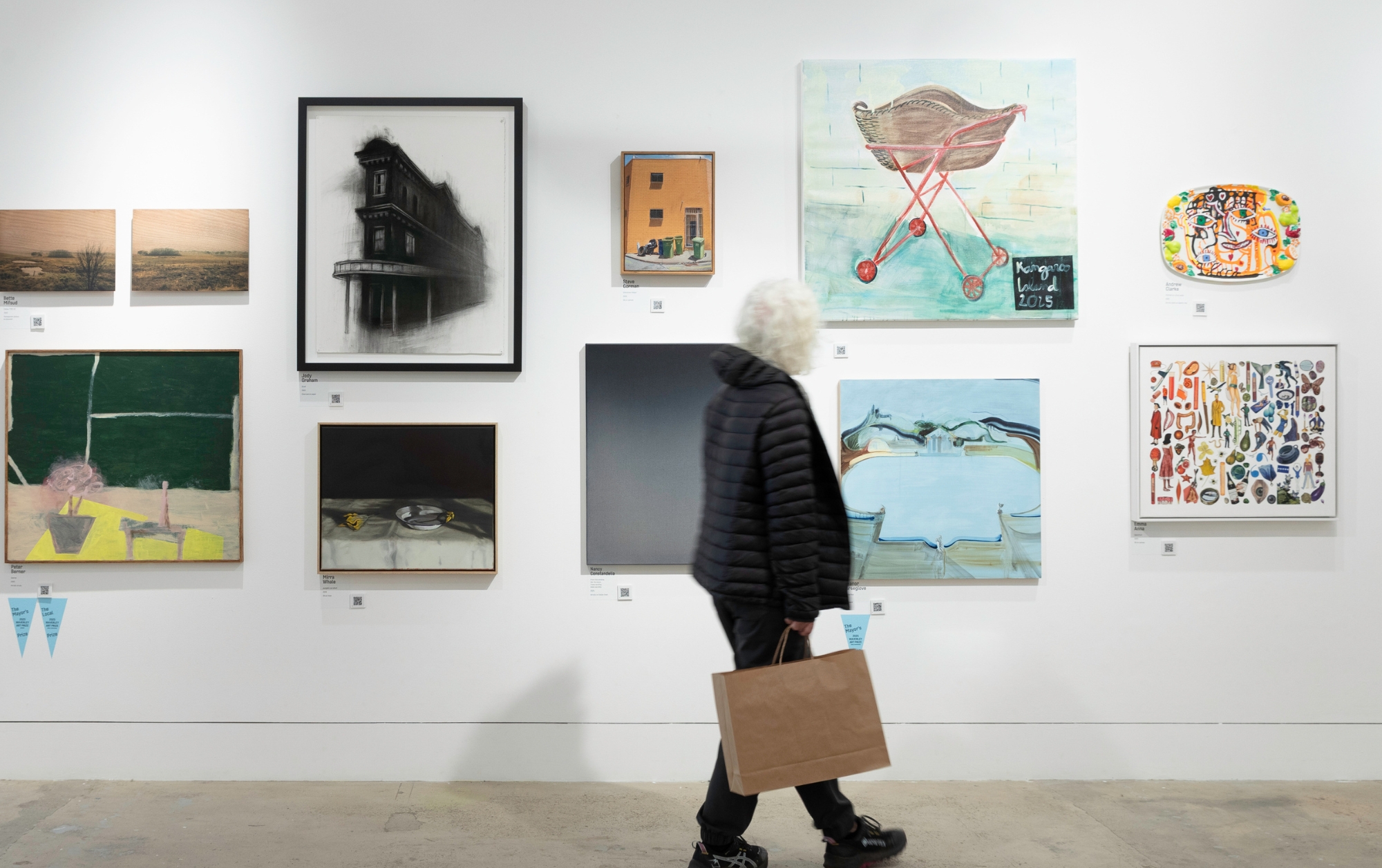 Image of a woman walking through the Waverley Art Prize exhibition.