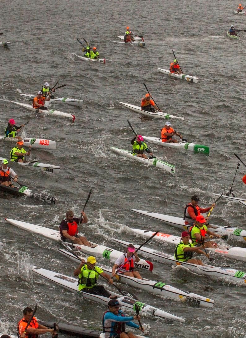 Numerous canoes and rowers on the water