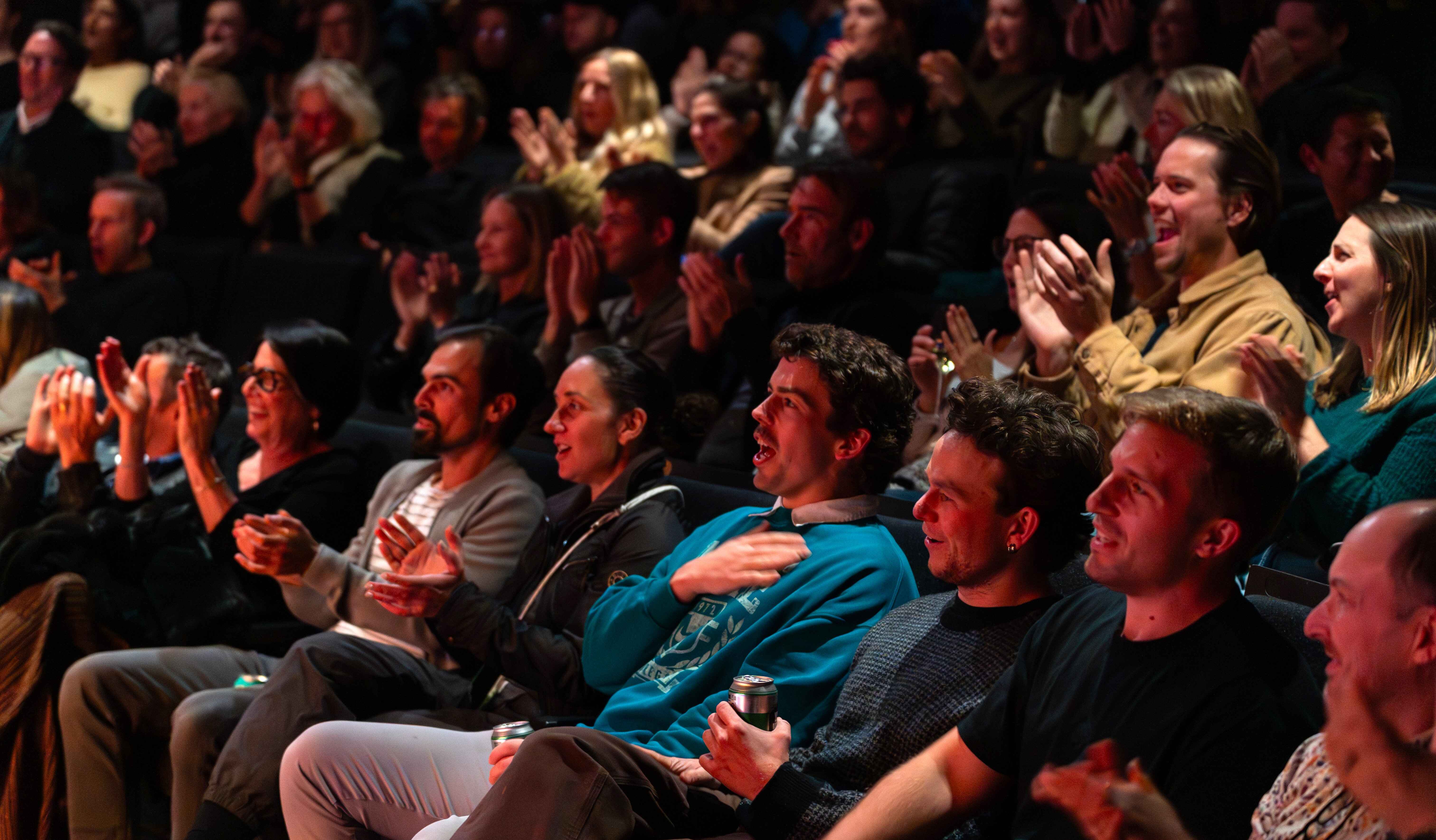 A packed crowd react and cheer 