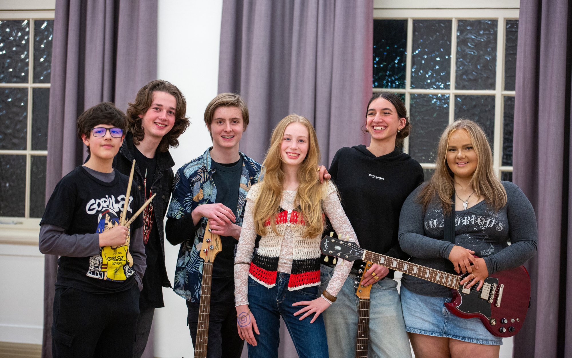 Young band smiling at camera in a hall