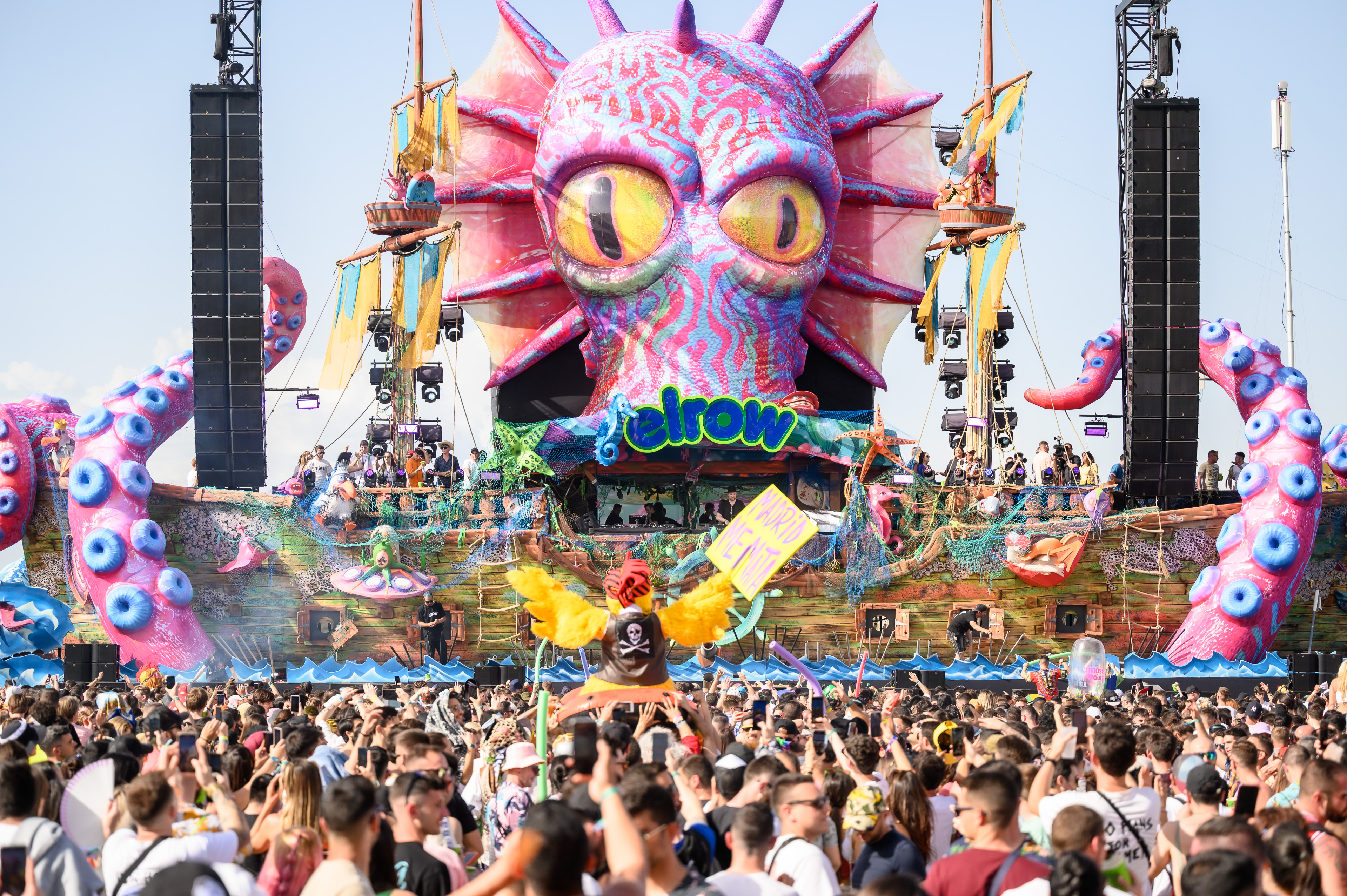 Image of a stage with a large sea creature adorning it, Infront of a crowd