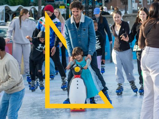 Man and child ice skating with a penguin toy