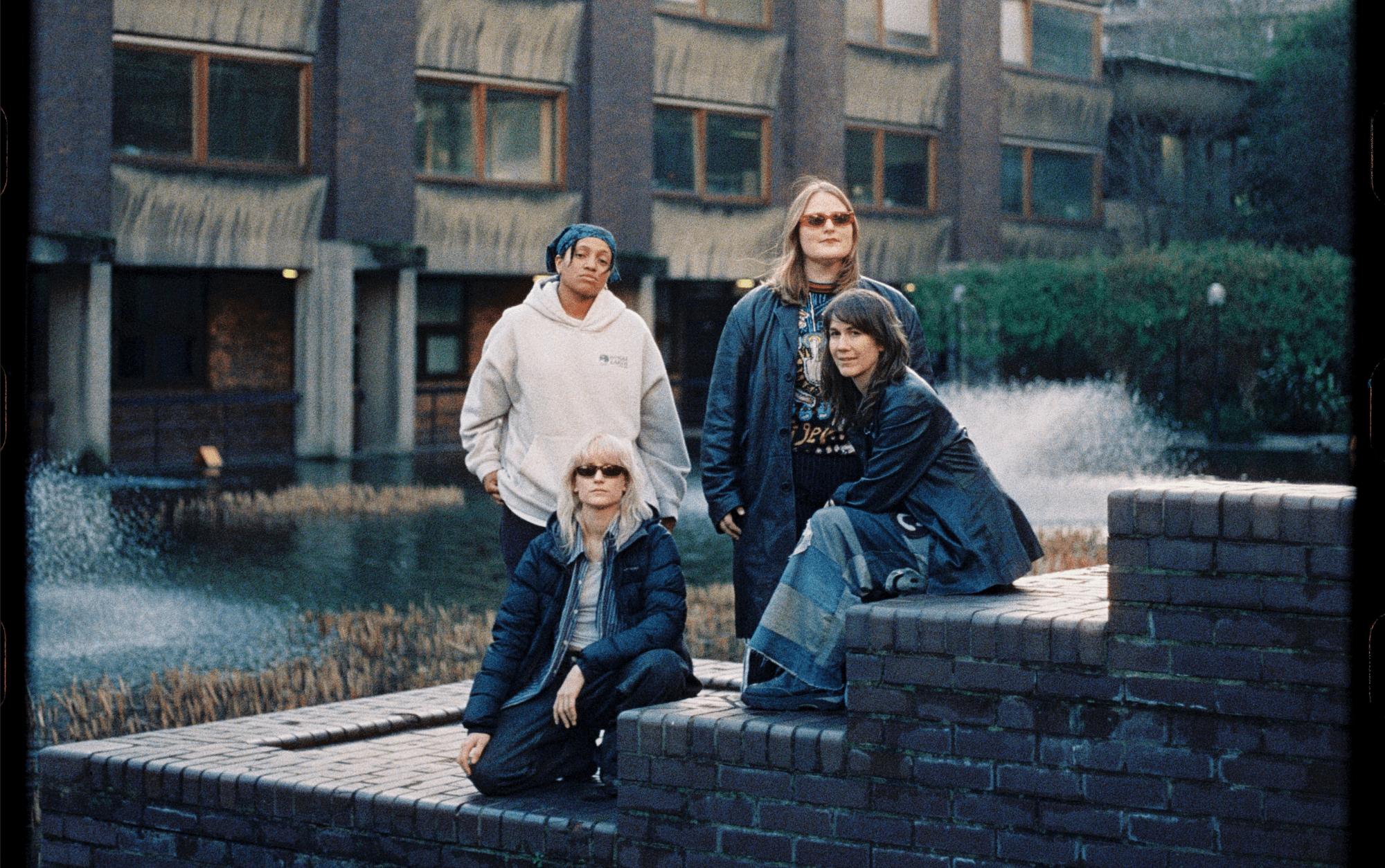 Four women in a rock band sitting in a couryard