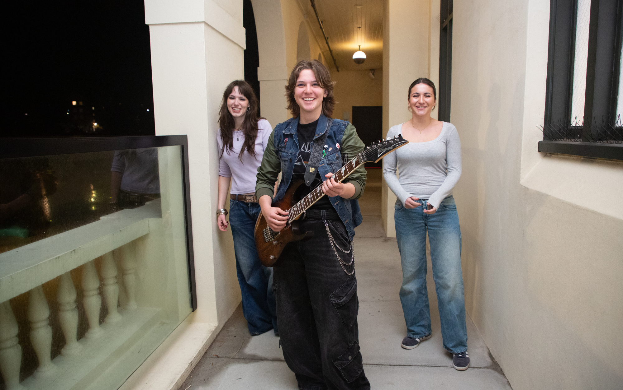 A trio of women musicians on a verandah smiling