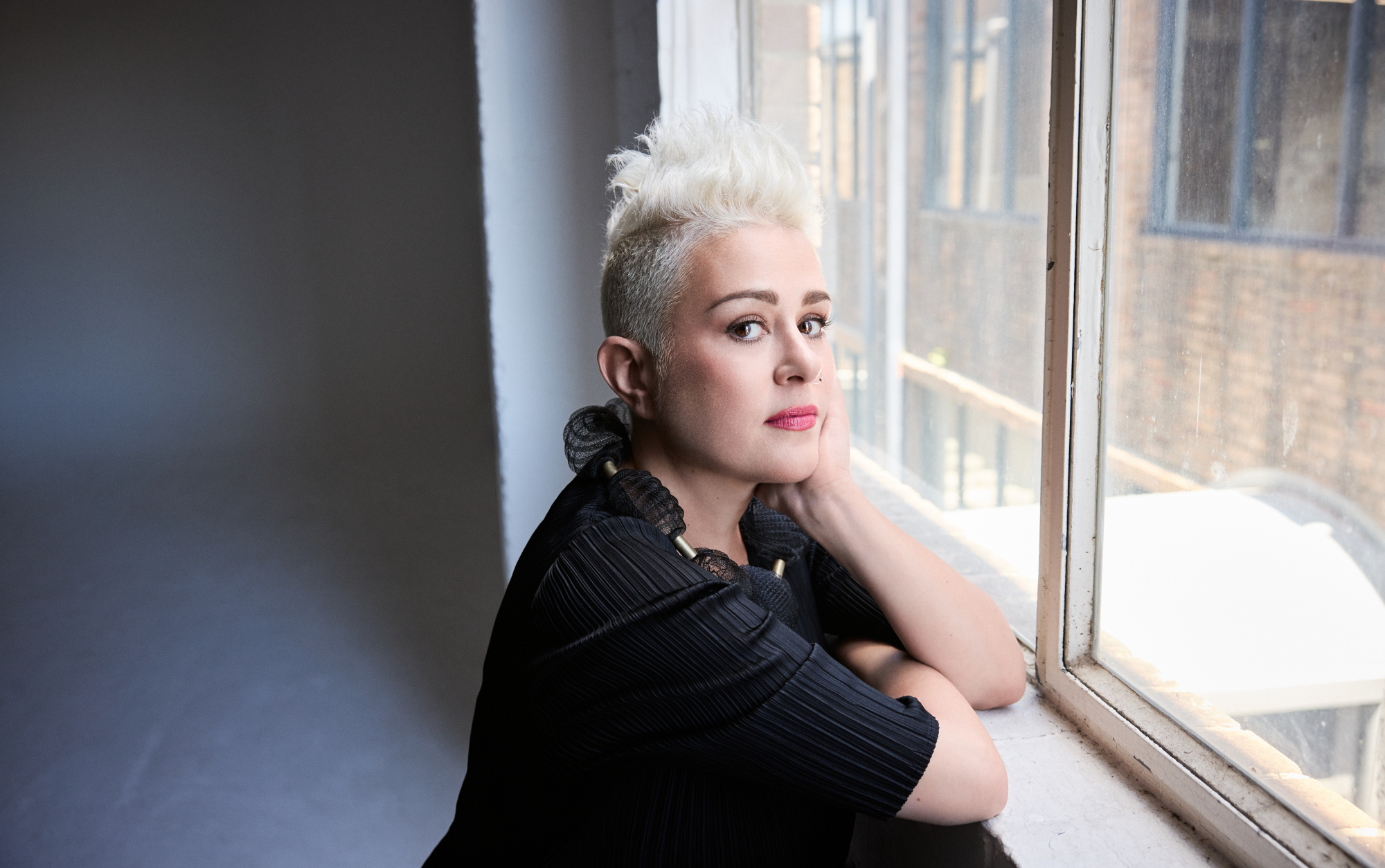Katie Noonan at window sill looking at camera