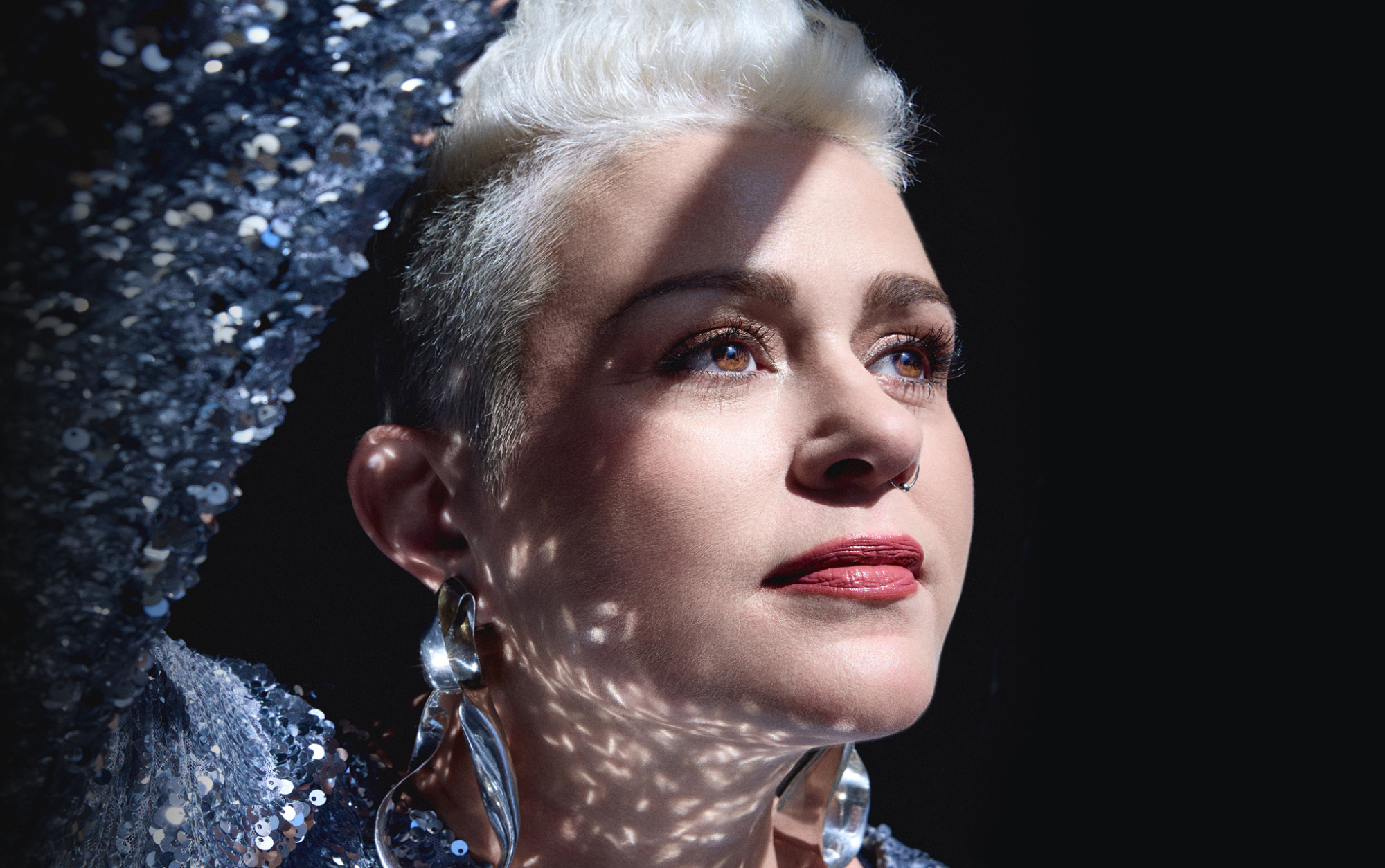 Katie Noonan in sparkle dress looking wistfully upwards