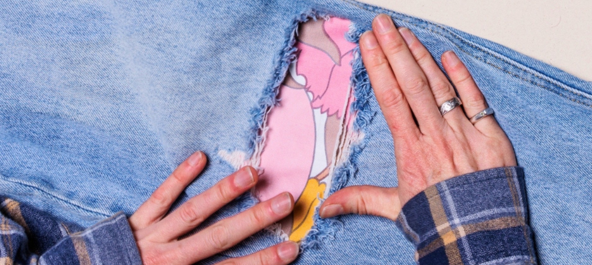 hands stitching jeans with creative flower fabric pattern
