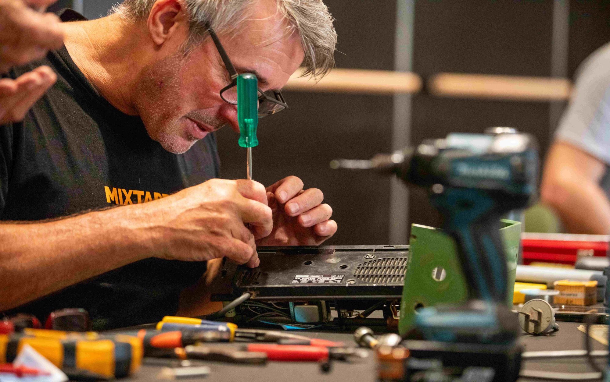Man repairing a gadget at a repair Cafe