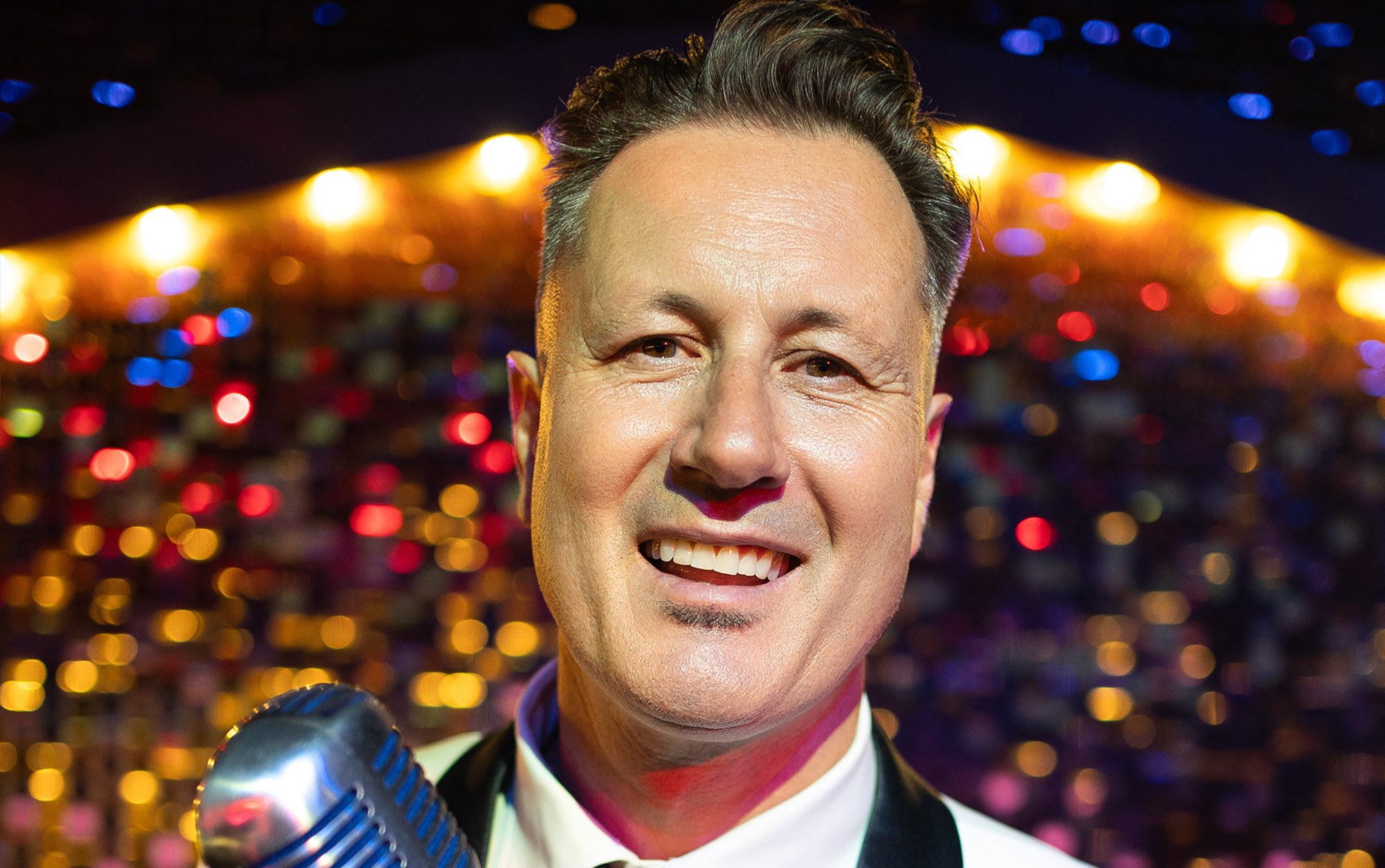 Smiling 50s singer with microphone head shot