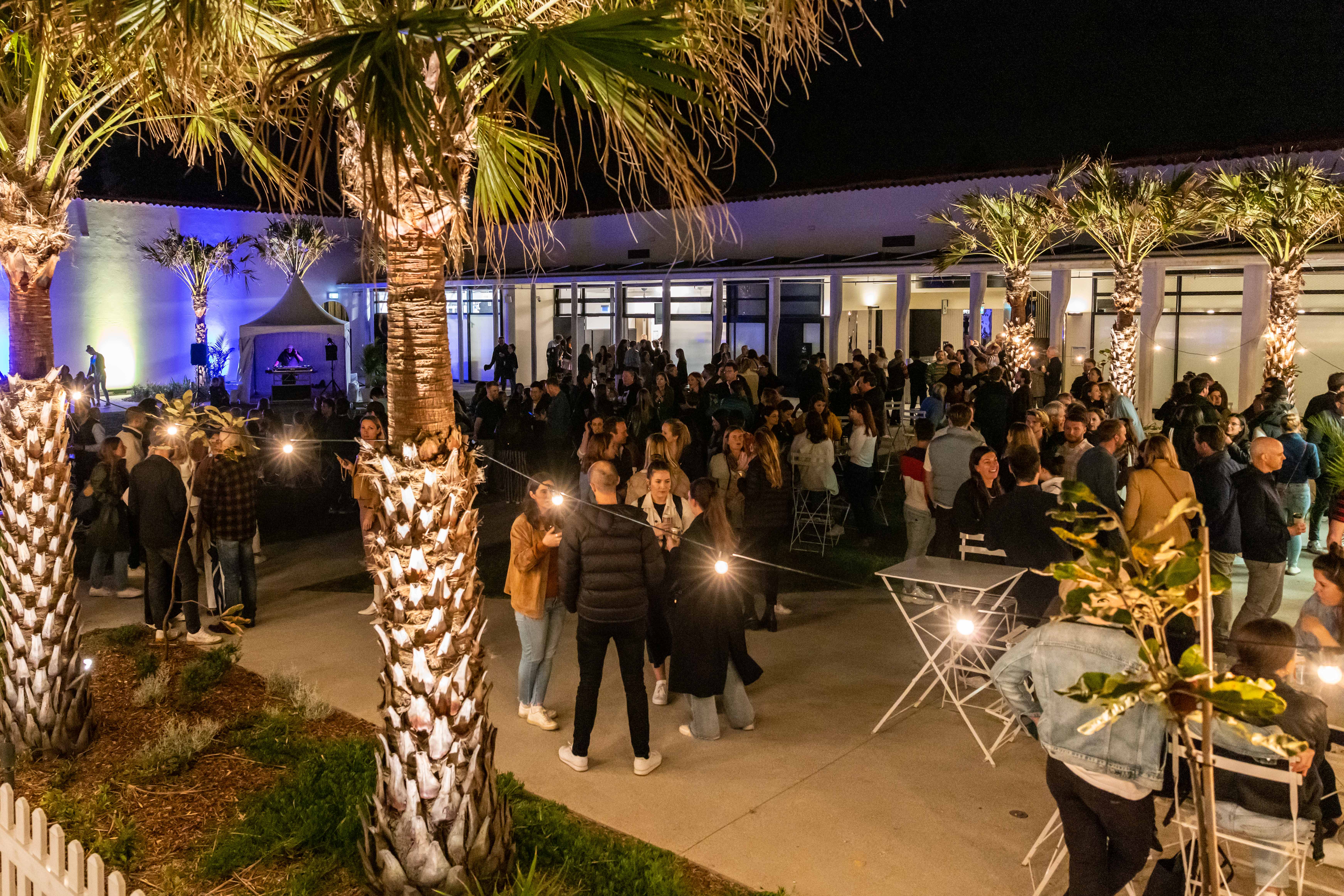 People gathering in the evening for an event in the Bondi Pavilion courtyard