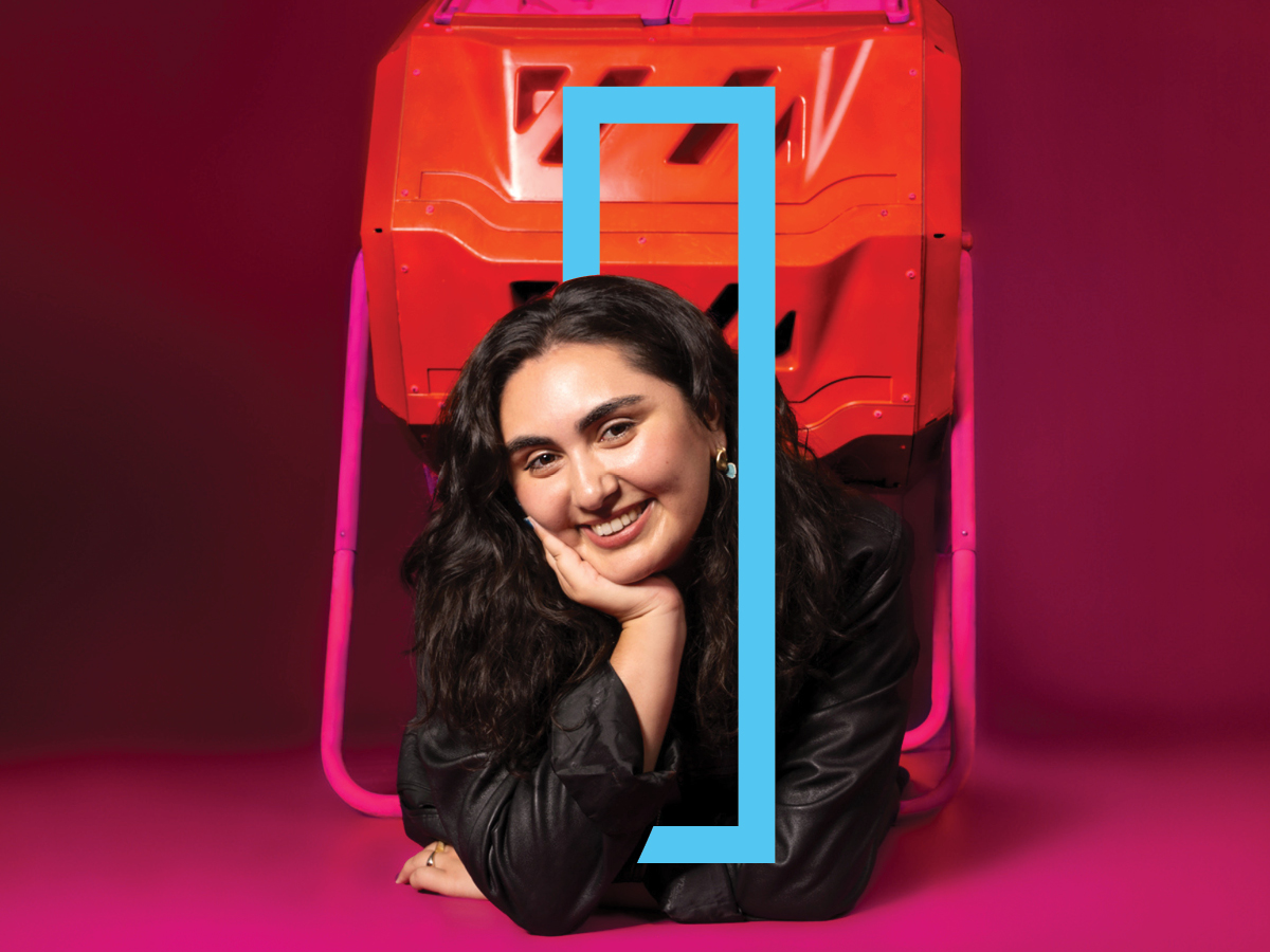 Comedian Madeleine Gandhi lies inside a pink compost bin