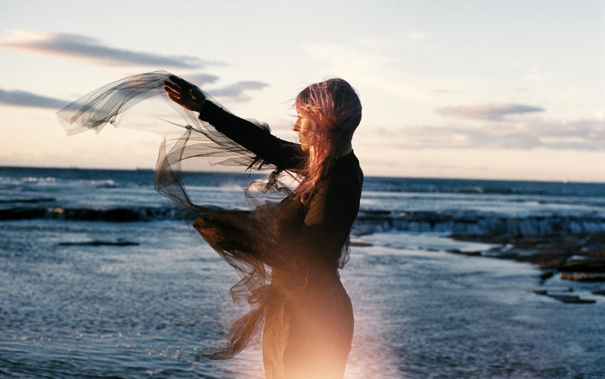 Female artist in an aqua blue dress at the beach