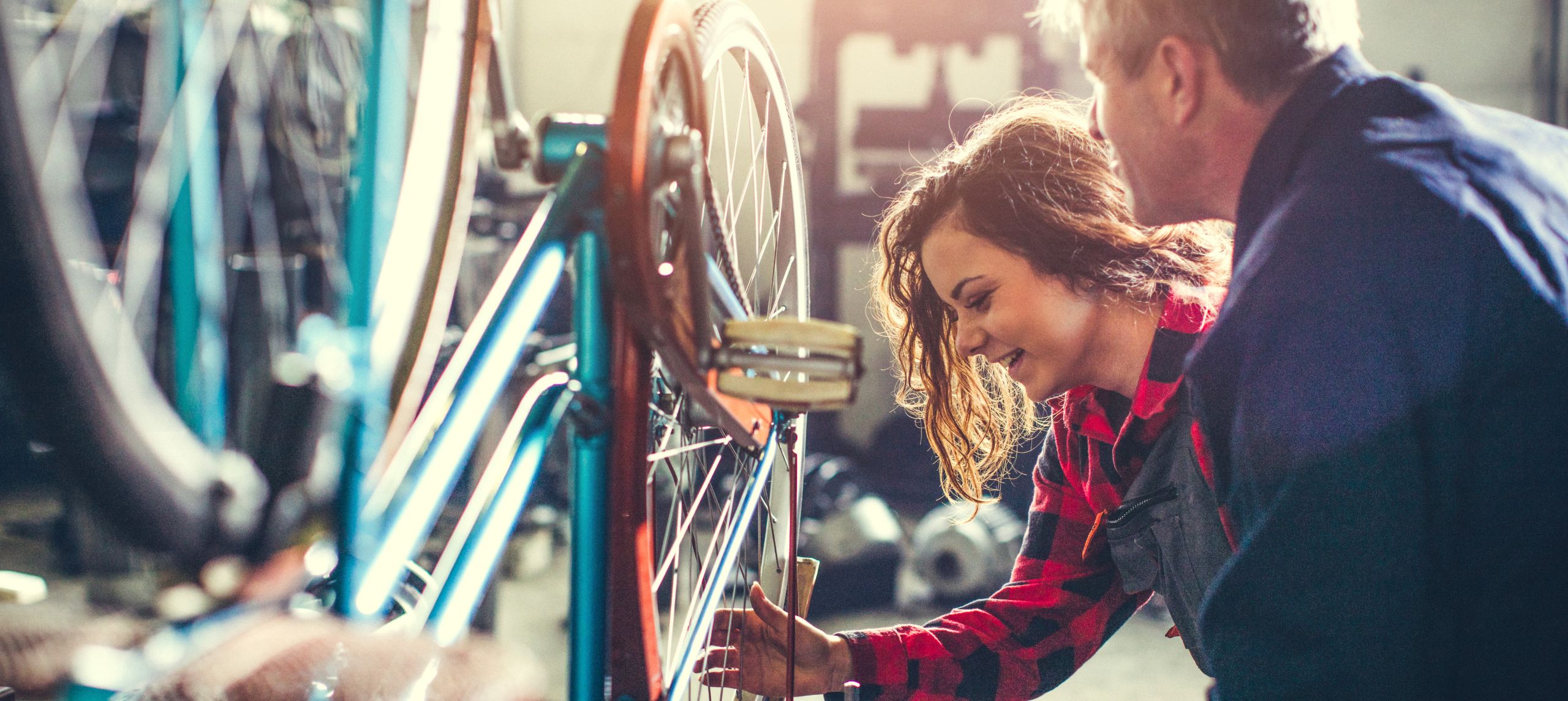 Young woman and man working on fixing a bike in a bike shop
