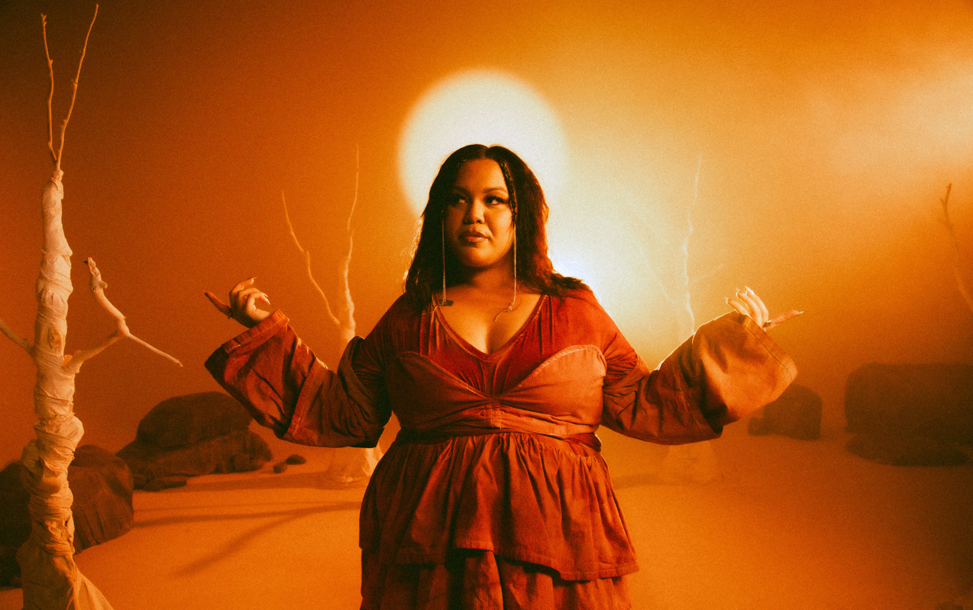 A woman with arms outstretched in bright warm orange light