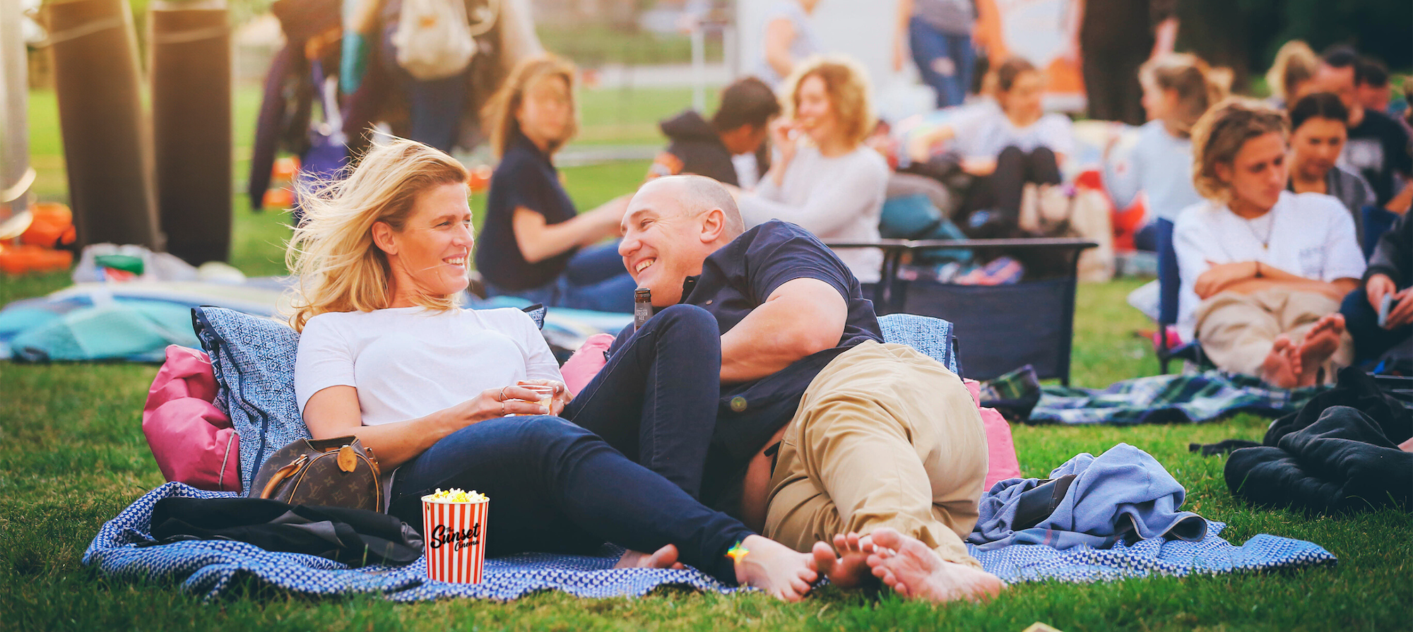 Couple laying down on grass for an outdoor movie