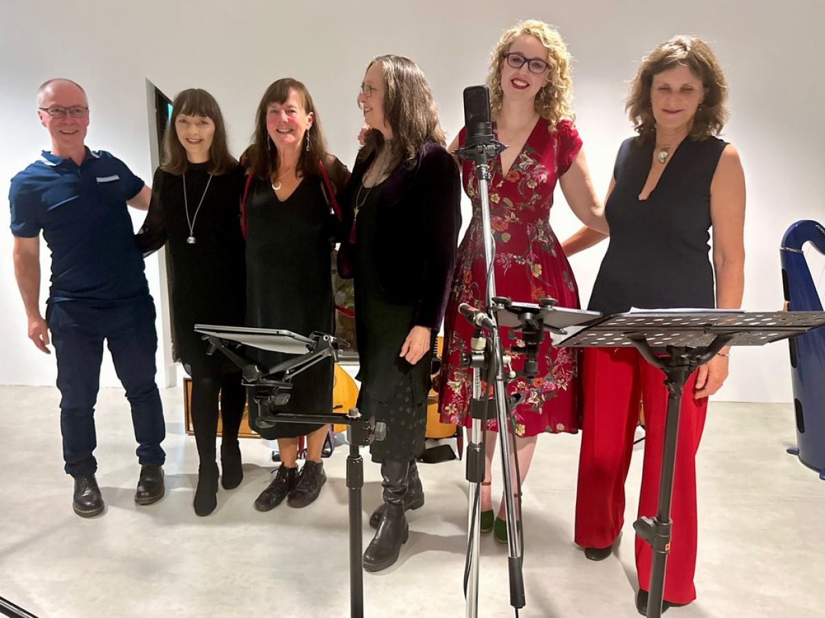 Performers standing in a white room with music stands