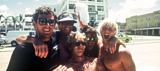 Five men smiling for a photo on the street at Bondi Beach. Image credit: Hugh McLeod