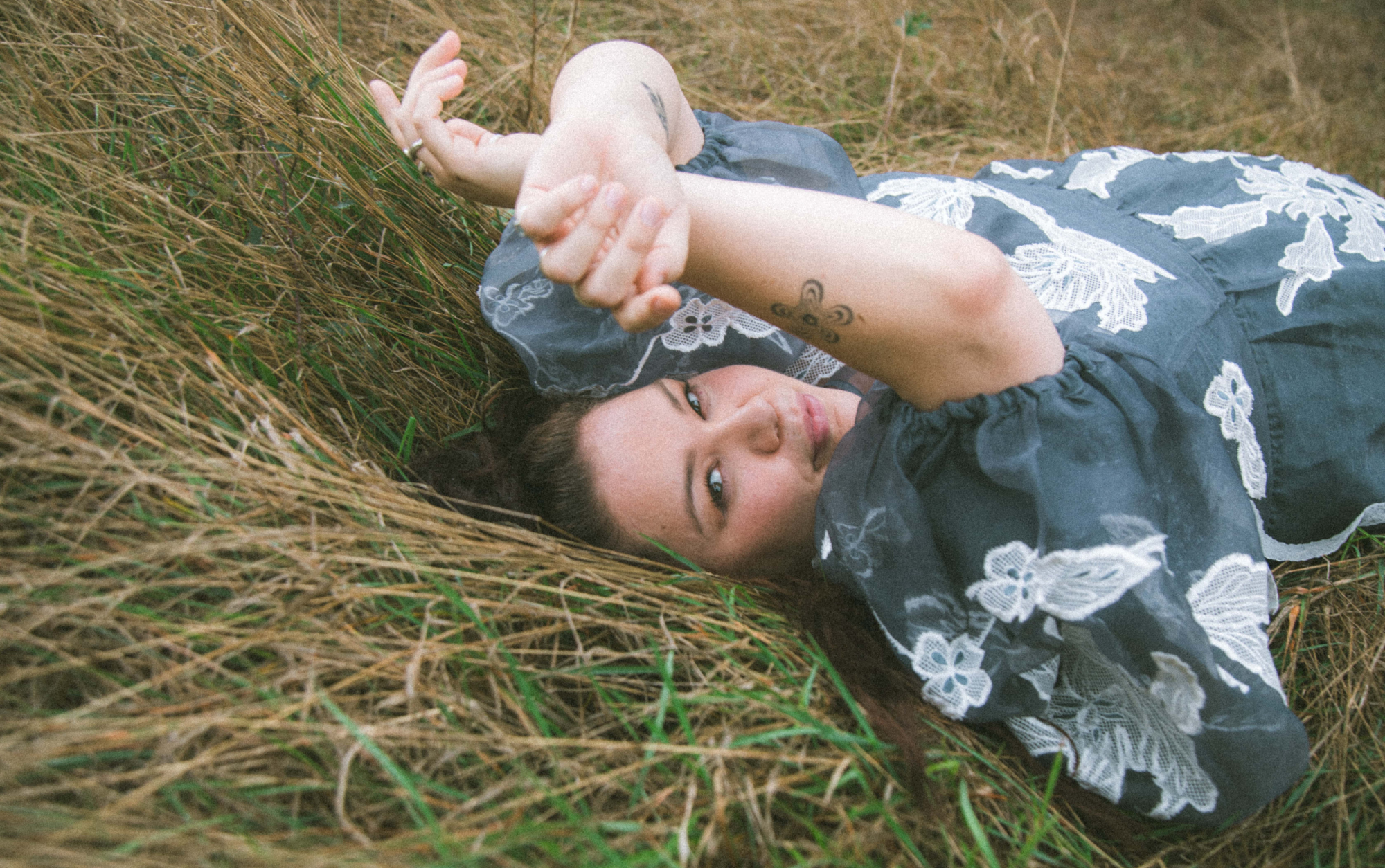 A woman lying on the grass looking backwards towards the camera
