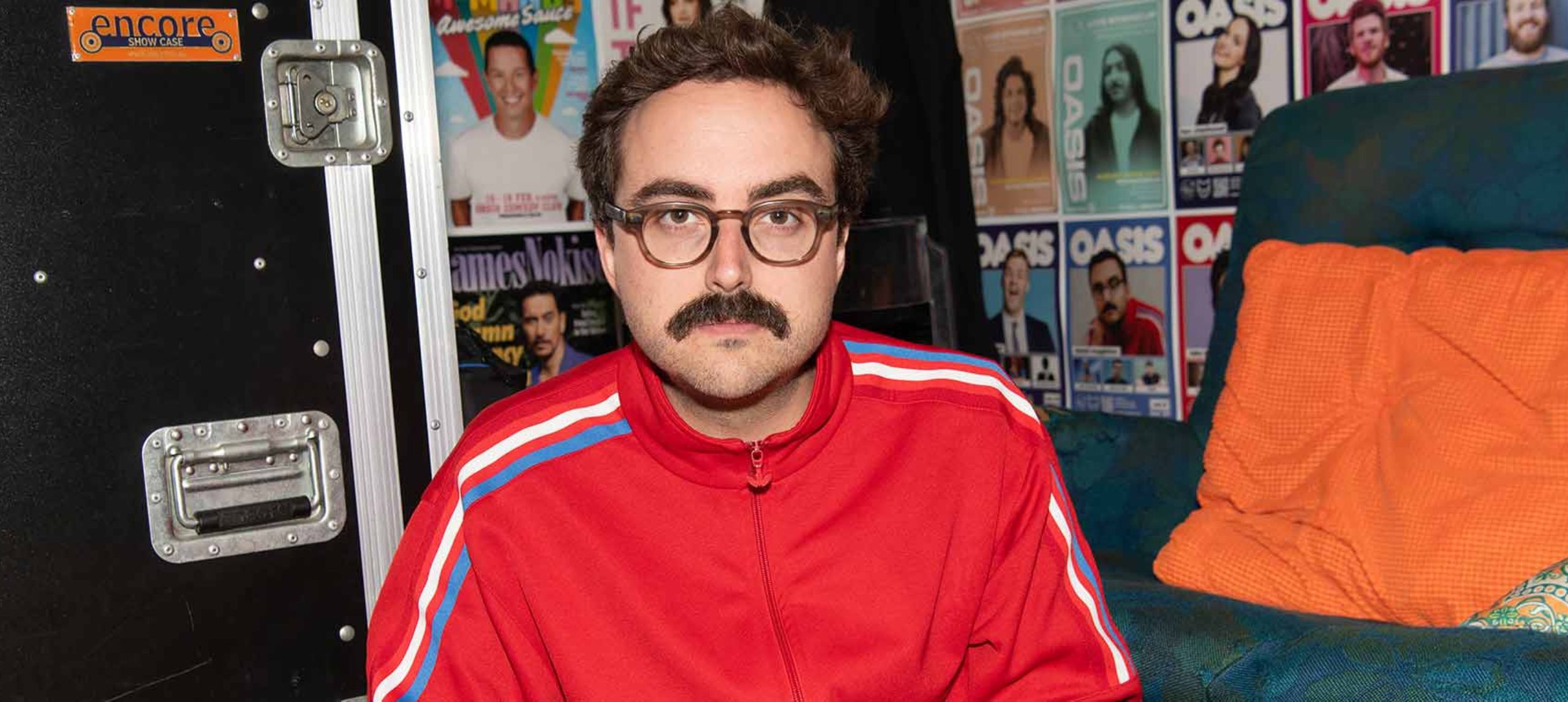 Daniel seated in red tracksuit