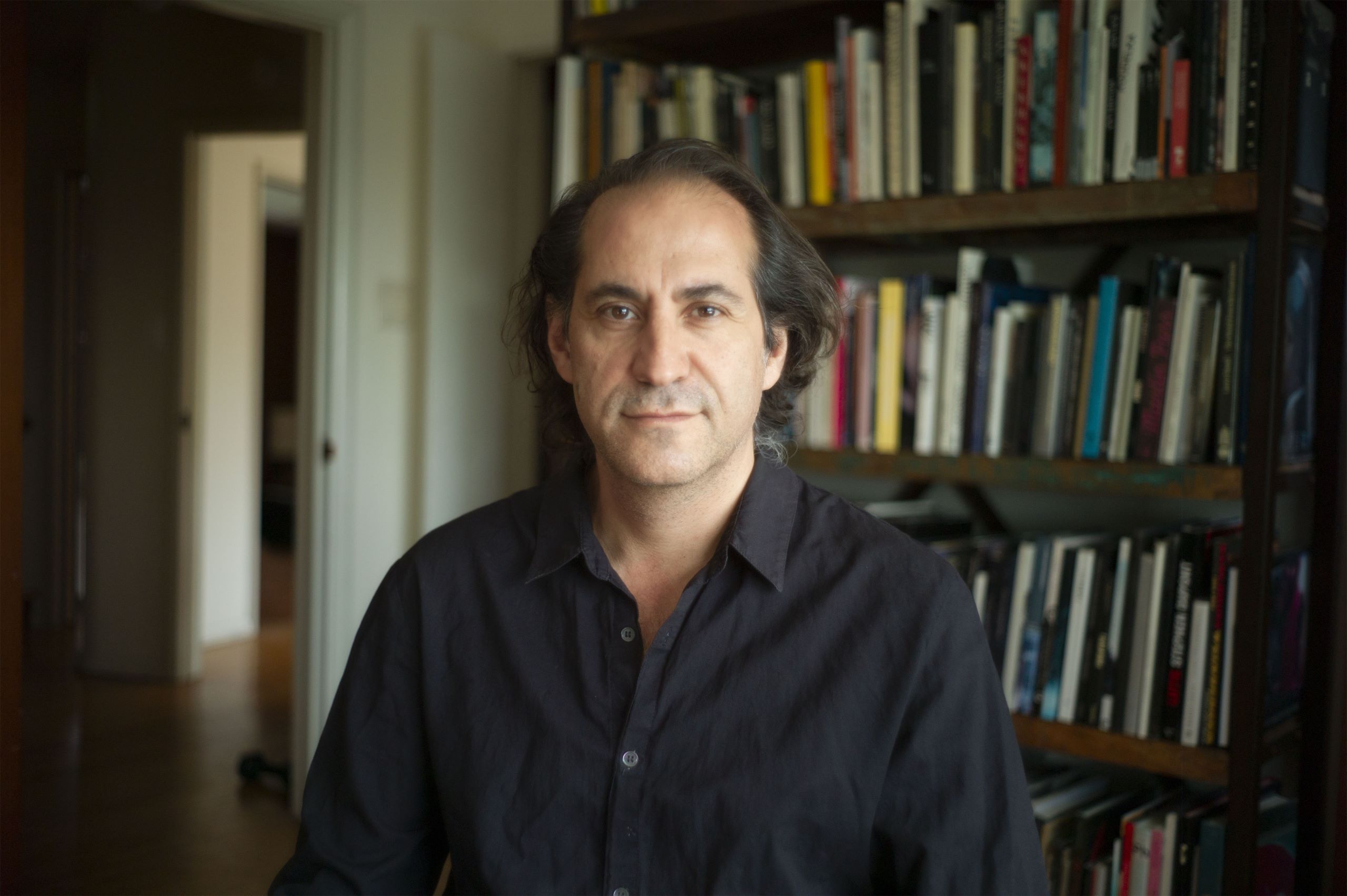 Steve Toltz in front of a bookshelf. Image Credit Nigel Bluck.
