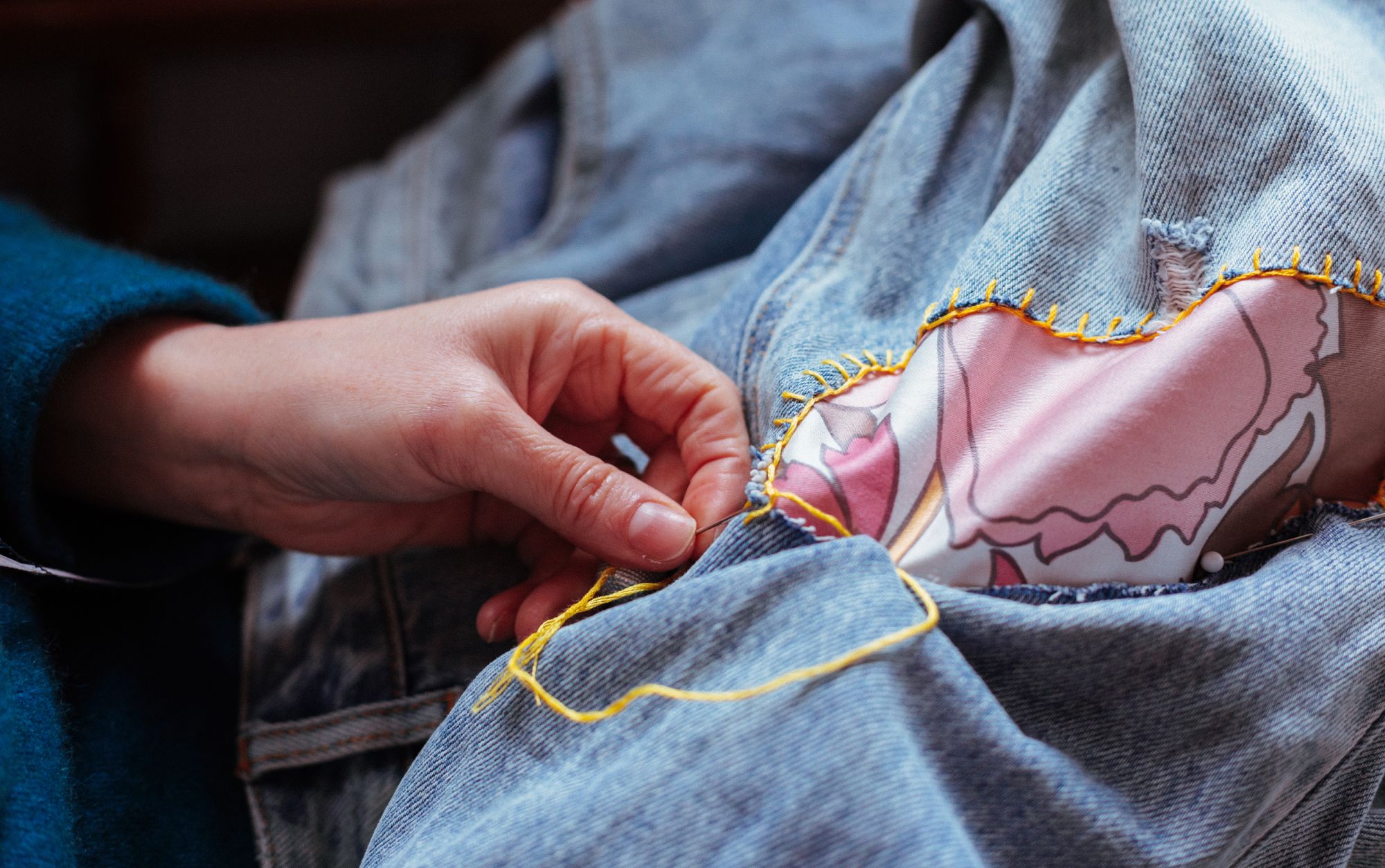 hands on jeans showing a patch of fabric about to be mended