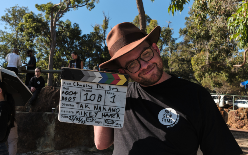 Student holding a clapper board during filming outside