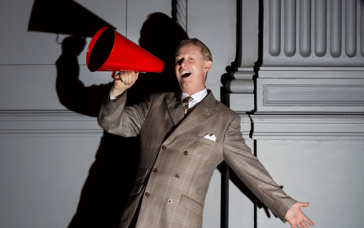 Singer with a big smile holding a megaphone